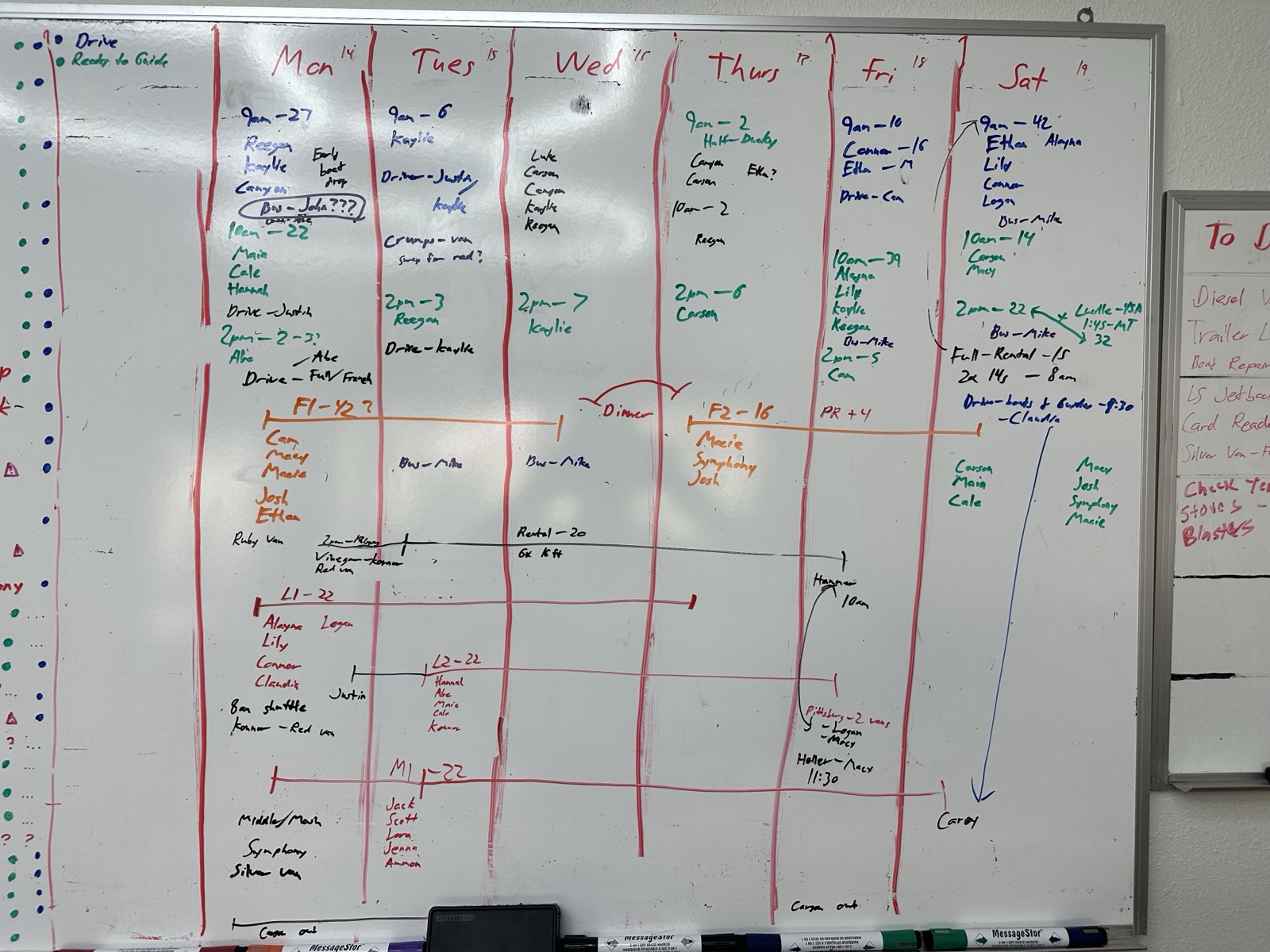 Our whiteboard during the season: a week of trips across the top, guide names written and rewritten under each day, multi-day trips drawn as lines across several days, vans and shuttles squeezed into the gaps, arrows and question marks where something still didn't fit.